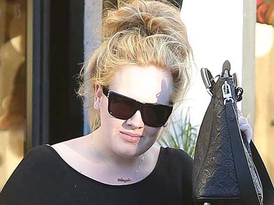 Adele mengenakan kalung bertuliskan Angelo